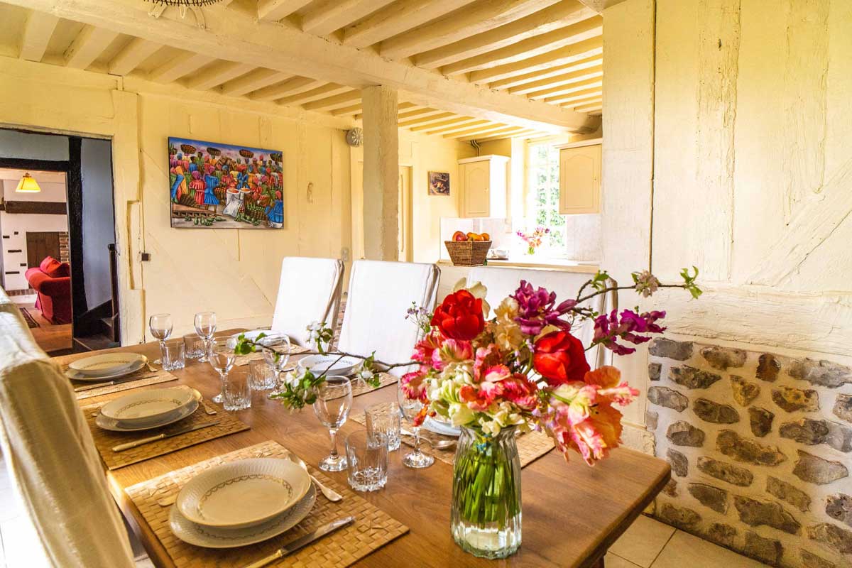 Table dressée et bouquet de fleurs dans la salle à manger, au Cottage du Manoir d'Argentel
